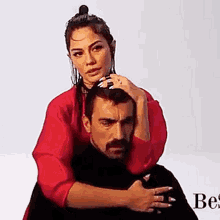 a woman is sitting on a man 's shoulders and holding his head .