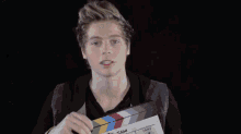a man is holding a clapper board that says " s sec sum " on it