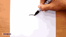 a person is drawing on a piece of paper with a marker that says sharpie