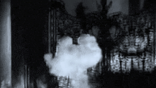 a black and white photo of smoke coming out of a building