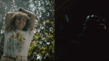 a woman in a white t-shirt is standing in the woods