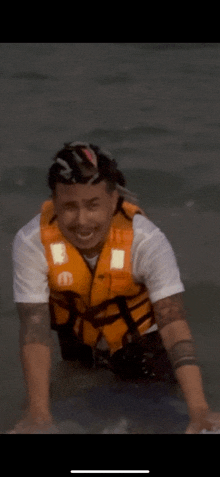 a man wearing an orange life vest with the letter e on the front