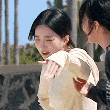 two women are standing next to each other and one is holding another woman 's arm .