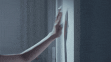 a person 's hand is reaching for a light switch on the wall