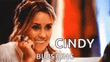 a woman is taking a picture of herself with the words cindy blushing behind her
