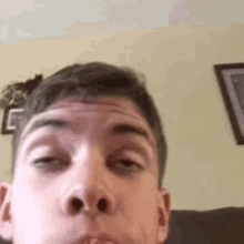 a young man is making a funny face in a living room .