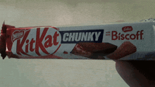 a person is holding a kitkat chunky biscoff candy bar