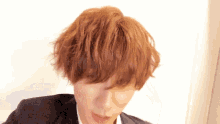 a man with red hair is wearing a suit and white shirt