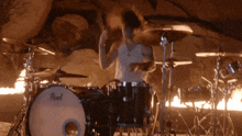 a man playing drums in a cave with a pearl drum set