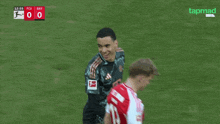 two soccer players on a field with tapmad written on the bottom of the screen