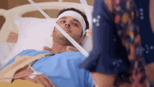 a man in a hospital bed has a bandage on his head