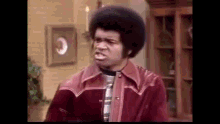 a man in a red jacket is making a funny face .