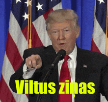 donald trump speaking into a microphone with the words viltus zinas written in yellow