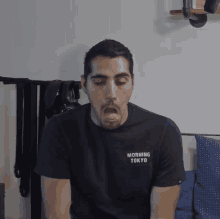 a man wearing a black shirt that says morning tokyo on the front
