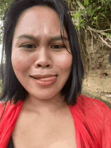 a woman wearing a red top making a funny face