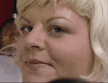 a close up of a blonde woman 's face with blue eyes