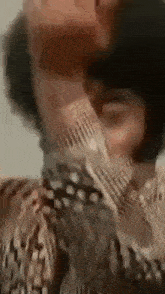 a man with a beard is covering his face with his hands .