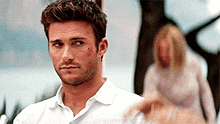 a man in a white shirt is standing in front of a woman in a white shirt .