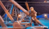 a man in armor is standing on top of a wooden structure .