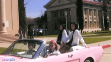 a group of girls in a pink car with the letters caf on the side