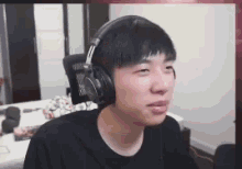 a man wearing headphones is sitting in a chair and looking at the camera .