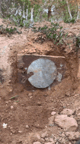 a large metal object is sitting in the dirt