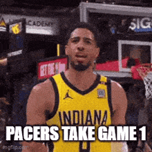 a basketball player wearing a yellow indiana pacers jersey is standing in front of a basketball net .