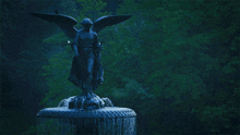 a fountain with a statue of a woman with wings