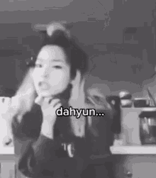 a black and white photo of a woman in a kitchen with the words `` dahyun '' written on the bottom .