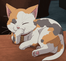 a calico cat is laying on a wooden table with its eyes closed