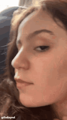 a close up of a woman 's face with the words gifsdayrol at the bottom .