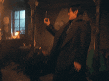 a man in a black coat is holding a gun