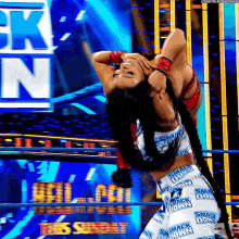 a woman in a wrestling ring is wearing a pair of pants that say ' smack down ' on them