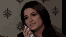 a woman with a ring on her finger talks on a cell phone