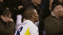 a man in a white and yellow jersey with the number 8 on the back