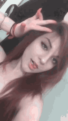 a woman with red hair is making a peace sign with her hand