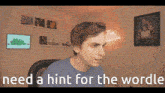 a man is sitting at a desk with the words need a hint for the wordle behind him