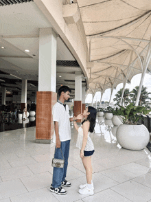 a man and a woman are standing next to each other on a tiled floor
