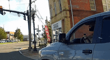 a man is driving a truck down a street in front of a building that says abercrombie