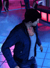 a man with a tattoo on his chest is standing on a tiled floor