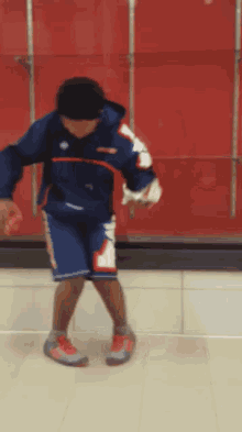 a person wearing a blue jacket and shorts with the word reebok on the front