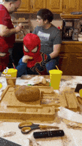 a little boy in a spiderman costume is eating a potato .