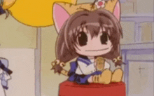 a cartoon girl with cat ears is sitting on a red block .
