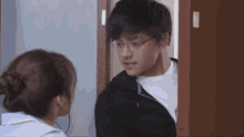 a man and a woman are standing next to each other in a doorway .