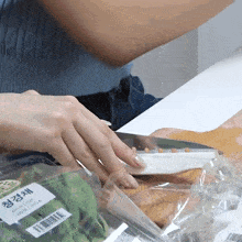 a person is cutting vegetables in a plastic bag with a label that says ' korean '