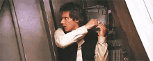 han solo is putting on his earring while standing in a doorway .