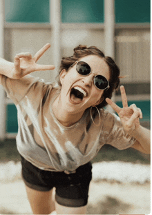 a woman wearing sunglasses makes a peace sign