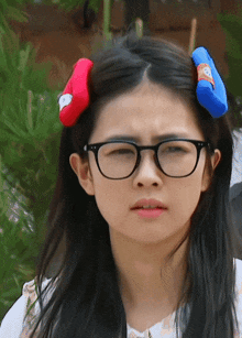 a girl wearing glasses and a red and blue headband with a face on it