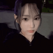 a close up of a woman taking a selfie with her eyes closed and a surprised look on her face .