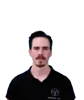 a man with a mustache and a black shirt looks at the camera